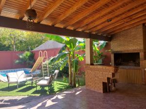 an outdoor patio with a fireplace and chairs and aitating at Habitación con baño privado y estacionamiento in San Martín