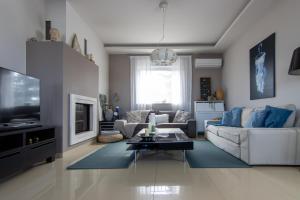 a living room with a couch and a tv at Villa Abelos in Artemida