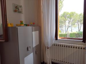 a kitchen with a white refrigerator and a window at Patrizia's Maison in Ripatransone