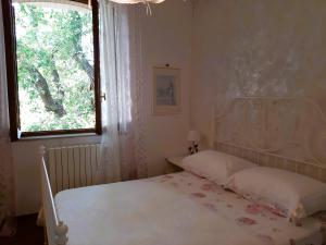 a bedroom with a white bed and a window at Patrizia's Maison in Ripatransone