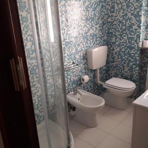 ein Bad mit einem WC, einem Waschbecken und einer Dusche in der Unterkunft Appartamento Le Cascate 1° Piano in Cittiglio