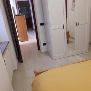 Habitación con cama, espejo y pasillo. en Appartamento Le Cascate 1° Piano, en Cittiglio