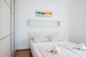 a bedroom with two beds and a painting on the wall at VDL Apartments in Trogir