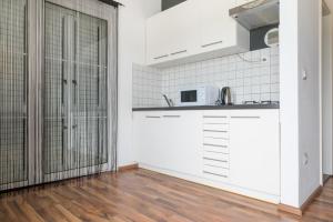 a kitchen with white cabinets and a wooden floor at VDL Apartments in Trogir