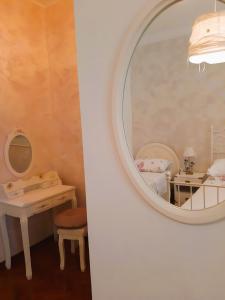 un espejo colgado en una pared junto a un dormitorio en Patrizia's Maison, en Ripatransone