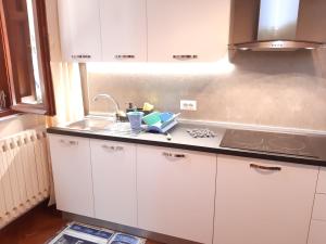 a kitchen with white cabinets and a sink at Patrizia's Maison in Ripatransone +39 photos