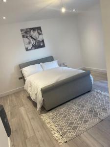 - une chambre avec un lit et un tapis au sol dans l'établissement Stylish and Cosy 2 bedroom flat in Croydon, à Croydon