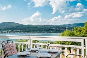 a table on a balcony with a view of the water at VDL Apartments in Trogir