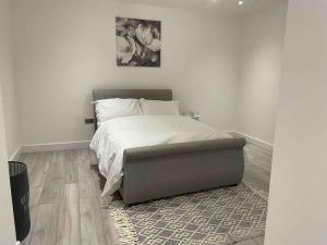 a bedroom with a bed and a ottoman at Stylish and Cosy 2 bedroom flat in Croydon in Croydon