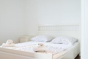 a white bed with pink and white pillows at VDL Apartments in Trogir