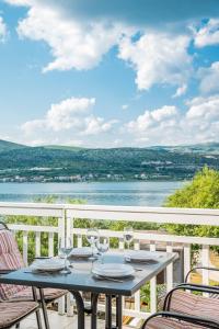 a table on a balcony with a view of the water at VDL Apartments in Trogir