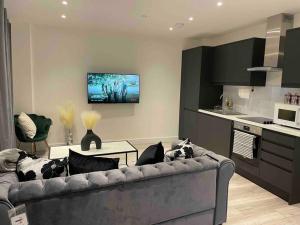 a living room with a couch and a kitchen at Stylish and Cosy 2 bedroom flat in Croydon in Croydon