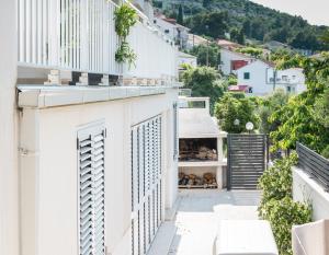 a white apartment with a balcony with a view of a city at VDL Apartments in Trogir