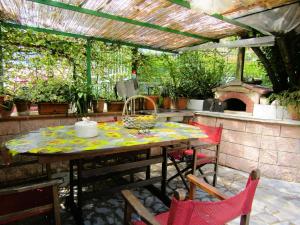 een patio met een tafel en stoelen en een buitenkeuken bij La Casa di Lilly e Nina in Camaiore