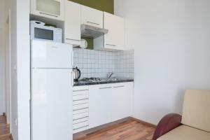 a small kitchen with white cabinets and a microwave at VDL Apartments in Trogir