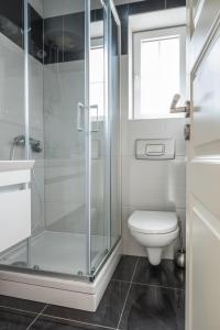 a bathroom with a toilet and a glass shower at VDL Apartments in Trogir