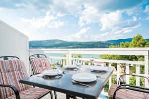 a table on a balcony with a view of the water at VDL Apartments in Trogir