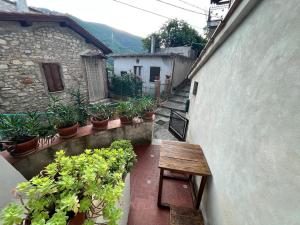 une allée avec un banc en bois et des plantes en pot dans l'établissement Appartamento a Valle San Martino di Spoleto, à Spolète