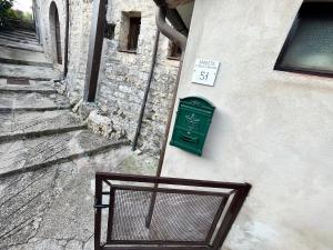 une porte verte sur le côté du bâtiment dans l'établissement Appartamento a Valle San Martino di Spoleto, à Spolète