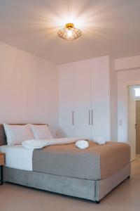 een slaapkamer met een groot bed en een licht bij Grand White Apartments in Agios Ioannis