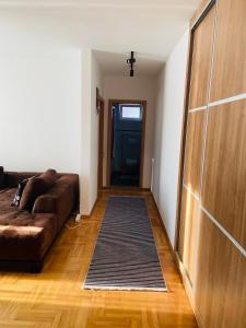 sala de estar con sofá marrón y puerta en My place, en Pristina