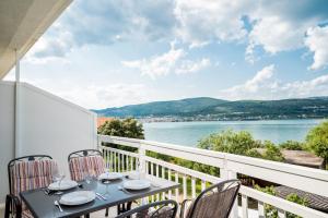 a balcony with a table and chairs and a view of the water at VDL Apartments in Trogir