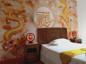 - une chambre avec un lit et un papier peint en dragon dans l'établissement Hostellerie des voyageurs, à Cassagnes-Bégonhès