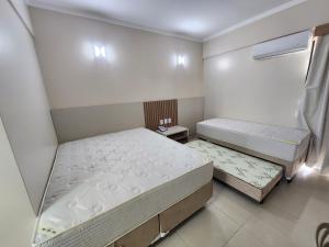 1 dormitorio con 2 camas y ventana en Spazzio diRoma - Apartamentos JN, en Caldas Novas