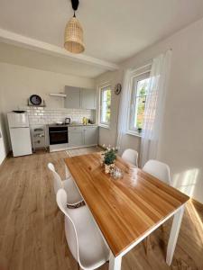 a kitchen with a wooden table and white chairs at Chalupa Krásný Buk, České Švýcarsko in Krásná Lípa