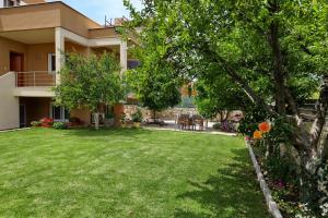 einen Hof vor einem Haus mit grünem Gras in der Unterkunft Fou's luxury apartment in Nafpaktos
