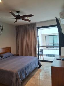 une chambre avec un lit et un ventilateur de plafond dans l'établissement Charming studio Akua Tulum Aldea Zama Premium, à Tulum