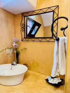 La salle de bains est pourvue d'une baignoire blanche et d'un miroir. dans l'établissement Resort La Casa Dei Fiori, à Pantelleria