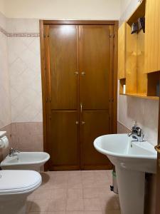 baño con 2 lavabos, aseo y armario en When in Alberese, en Alberese