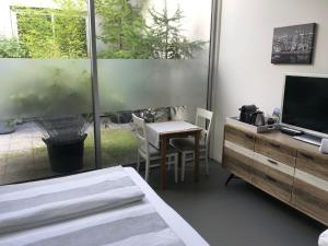 - une chambre avec un lit, un bureau et une télévision dans l'établissement Villa Yburg, à Amsterdam