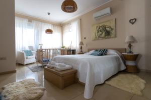 a bedroom with a large bed and a living room at Villa Abelos in Artemida