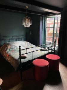 a bedroom with a bed with two red stools at B&B Suupmarkt in Dokkum