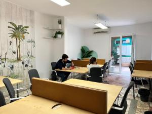 a group of people sitting at tables in a room at Trip'n'Hostel Chill Zone in Tirana