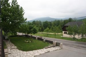 a view of a yard with a fence and a house at Guest House Tone in Poljanak