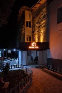 een nachtzicht op een hotel met een bord erop bij Nilhan Otel in Ören