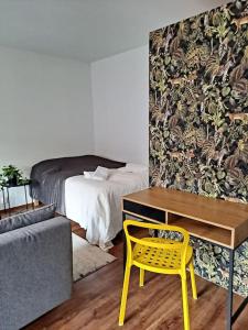 1 dormitorio con escritorio amarillo y 1 cama en Puotilan idylli meren lähellä, en Helsinki