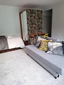 ein Wohnzimmer mit einem Sofa und einem Bett in der Unterkunft Puotilan idylli meren lähellä in Helsinki