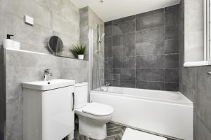 a bathroom with a toilet and a sink and a bath tub at Modern 2bed Apartment in Worksop in Worksop