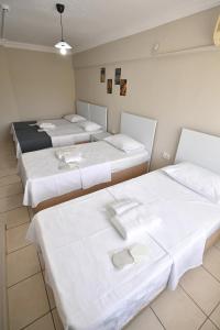 eine Gruppe von 4 Betten in einem Zimmer in der Unterkunft Nilhan Otel in Ören