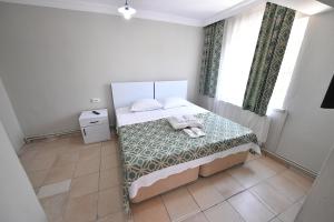 ein kleines Schlafzimmer mit einem Bett und einem Fenster in der Unterkunft Nilhan Otel in Ören