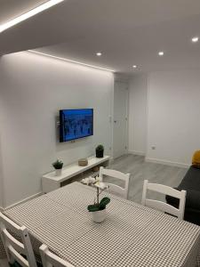 a dining room with a table and chairs and a tv at Apartamento Temático Cantabria in Camargo