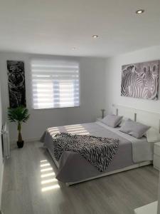 1 dormitorio con 1 cama grande con una foto de cebra en la pared en Apartamento Temático Cantabria, en Camargo
