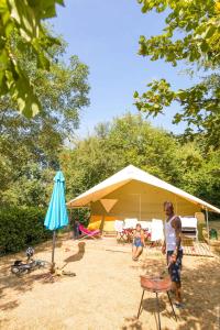 un homme et un enfant debout devant une tente dans l'établissement Camping La Bergerie, à La Chapelle-Achard 37 autres photos