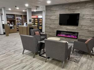 a lobby with chairs and a fireplace and a tv at Candlewood Suites Tuscaloosa, an IHG Hotel in Tuscaloosa