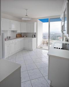 eine Küche mit weißen Schränken und Meerblick in der Unterkunft Panoramic view of Marseille for two in Marseille