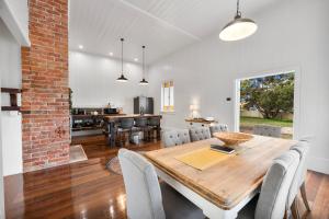 a dining room and kitchen with a wooden table and chairs at The Bank House Ulmarra in Ulmarra